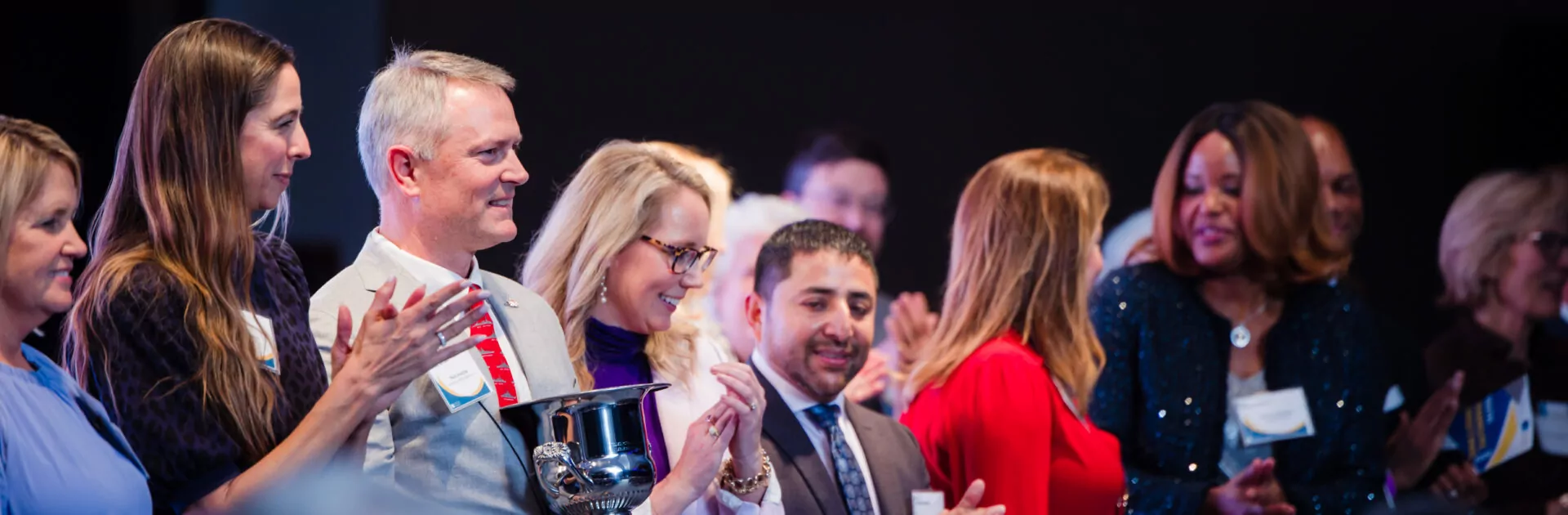 Chamber members organize for a photo with an award at the Chamber's annual meeting.