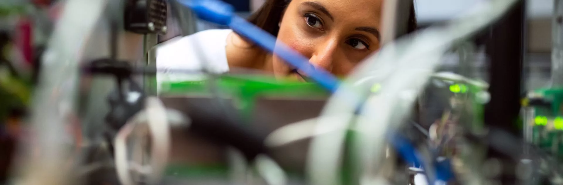 Female engineer looks through wires.