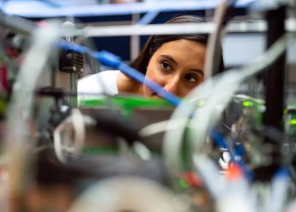 Female engineer looks through wires.