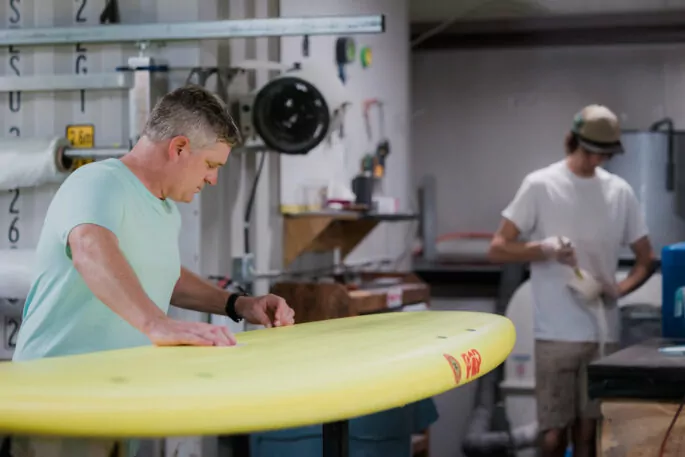 Man finishes building a surfboard.