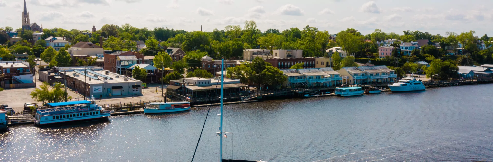 Overview of catamaran sailing on the Cape Fear River by downtown Wilmington.