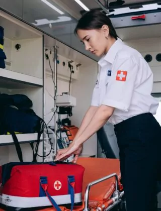 Parameic packer her go-bag in the back of an ambulance.