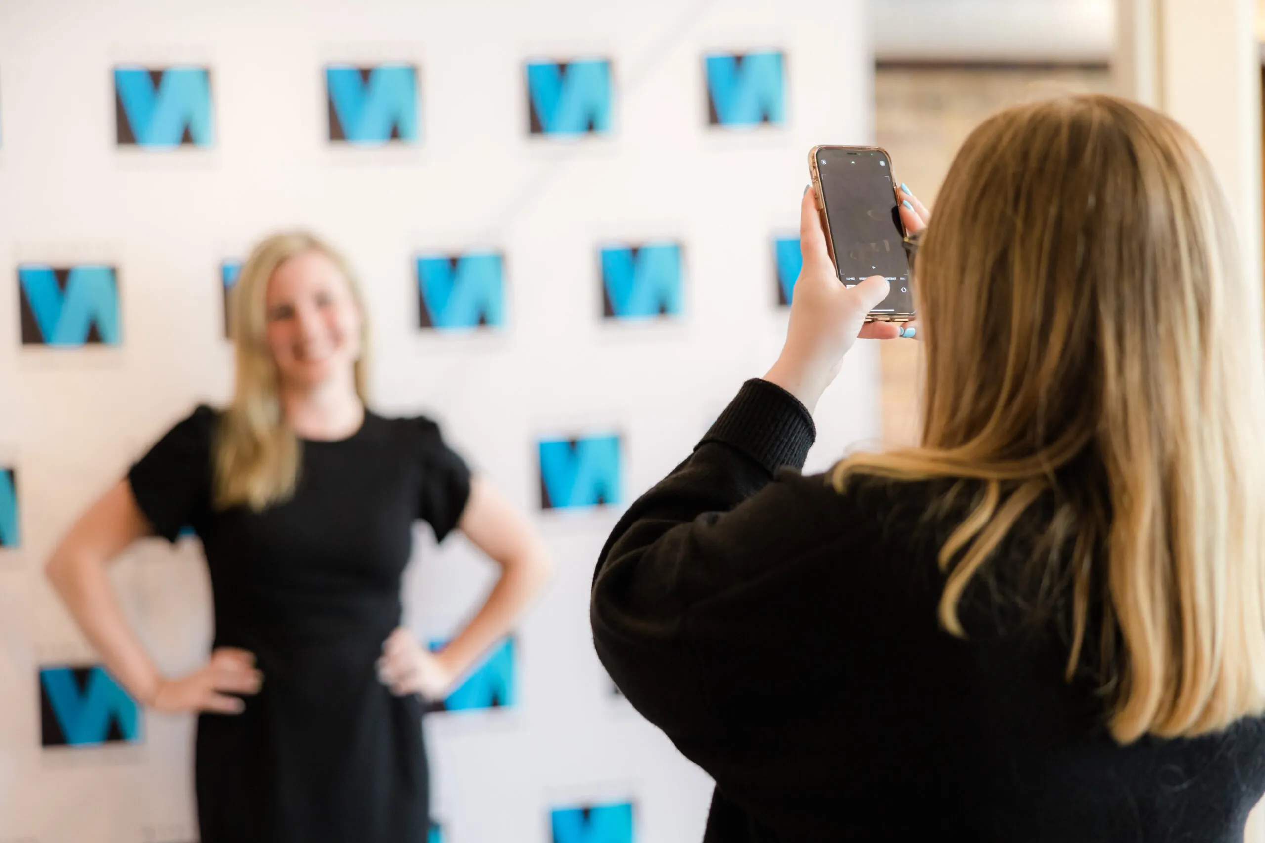 Persoon taking a photo of another in front of a Wilmington Chamber.