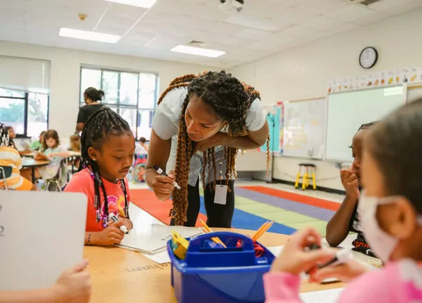 Teacher works with young student to understand concept.