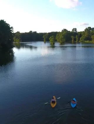 Two people kayak on the Cape Fear river.