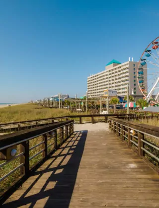 Wooden pathway to Carolina Beach and a colorful ferris Wheel
