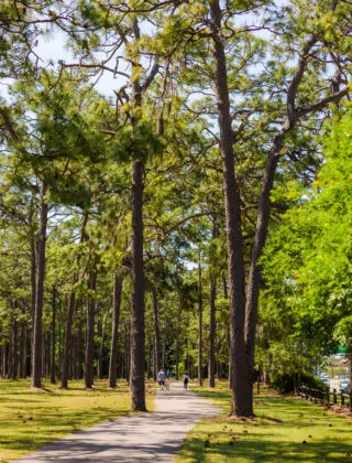 People strolling on paved path in Long Leaf Park.