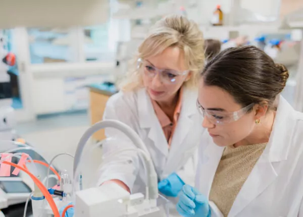 Two female pharmaceutical scientists work together in a lab.